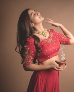 Neha Pathan celebratory expression in red lehenga Diwali theme