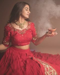 Traditional oil lamps complementing Neha Pathan red lehenga shoot