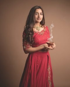Neha Pathan celebratory expression in red lehenga Diwali theme
