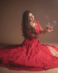 Neha Pathan red lehenga with traditional diya festive studio setup