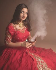 Neha Pathan celebratory expression in red lehenga Diwali theme