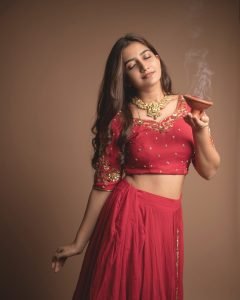 Neha Pathan celebratory expression in red lehenga Diwali theme