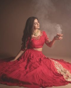 Traditional oil lamps complementing Neha Pathan red lehenga shoot
