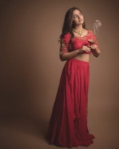 Traditional oil lamps complementing Neha Pathan red lehenga shoot
