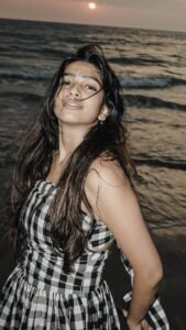 Ananthika walking barefoot near ocean in casual summer outfit