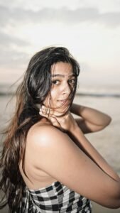 Ananthika walking barefoot near ocean in casual summer outfit