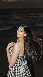 Ananthika Sanilkumar in white crop top and denim shorts on beach