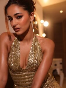 Close-up of Ananya with wet-look bun and glossy lids in metallic dress