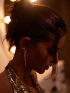 Close-up of Ananya with wet-look bun and glossy lids in metallic dress