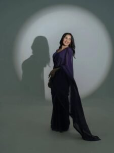 Anikha posing among jacaranda trees in purple saree