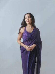 Anikha posing among jacaranda trees in purple saree