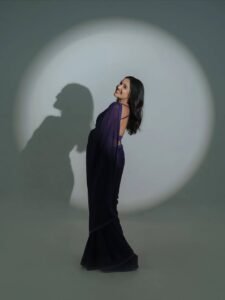 Anikha posing among jacaranda trees in purple saree