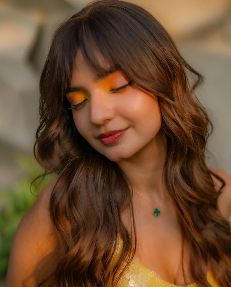 Anushka Sen with glossy lips and high ponytail in yellow outfit