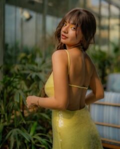 Anushka Sen with glossy lips and high ponytail in yellow outfit