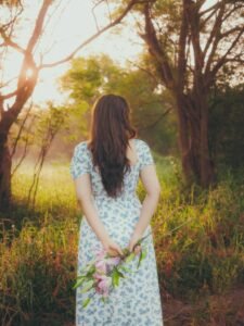 Ayesha walking barefoot on forest path with woven basket