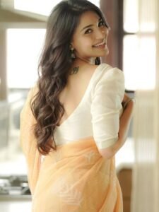 Close-up of Dharshna wearing pearl earrings and low bun in ethnic attire