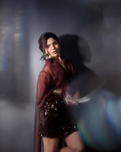 Full-length shot of Divya posing in thigh-high slit red dress