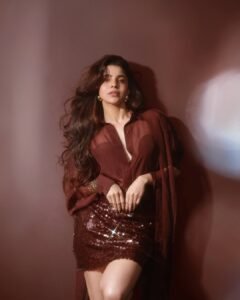 Full-length shot of Divya posing in thigh-high slit red dress