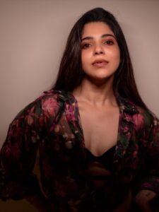 Full-length shot of Divya posing with hands on hips in studio lighting