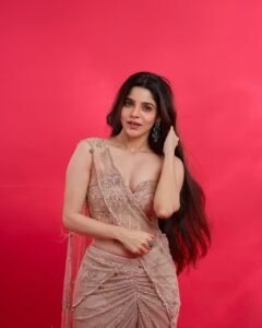 Full-length shot of Divya posing with hands on hips in studio lighting