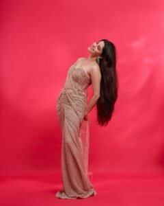 Full-length shot of Divya posing with hands on hips in studio lighting