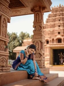 Eesha sitting by window in blue saree with antique mirror backdrop