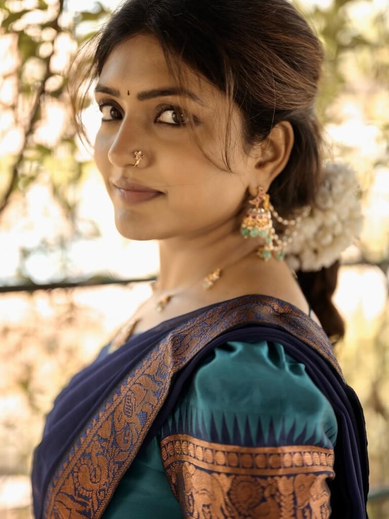 Eesha sitting by window in blue saree with antique mirror backdrop