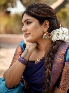 Eesha sitting by window in blue saree with antique mirror backdrop