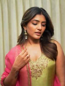 Close-up of Eesha wearing gold jhumkas and pink bangles