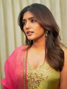 Close-up of Eesha wearing gold jhumkas and pink bangles