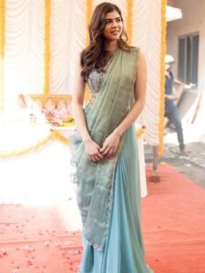 Kalyani sitting by window in green saree with antique mirror backdrop
