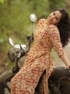 Close-up of Komalee with low ponytail and woven tote bag