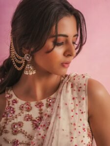 Preethi walking barefoot near ocean waves in minimalist white dress