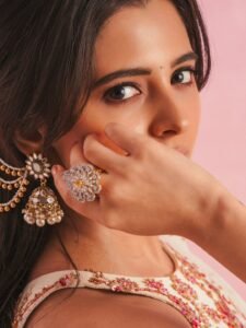 Close-up of Preethi with loose waves and straw tote bag in white outfit