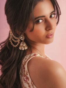 Close-up of Preethi with loose waves and straw tote bag in white outfit