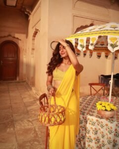 Trisha posing near stone pillar in royal Karnataka traditional attire