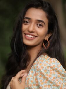 Close-up of Trupti with straw hat and loose waves in floral outfit